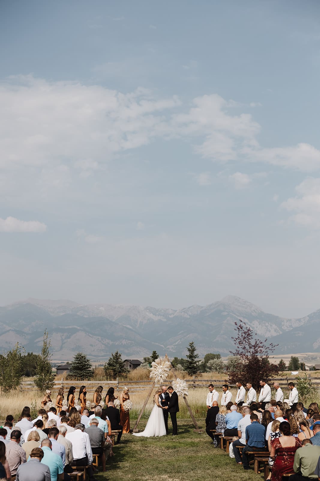 Beautiful ceremony photo of bride and groom standing in front of the bridger mountains at their wedding in bozeman, mt. 