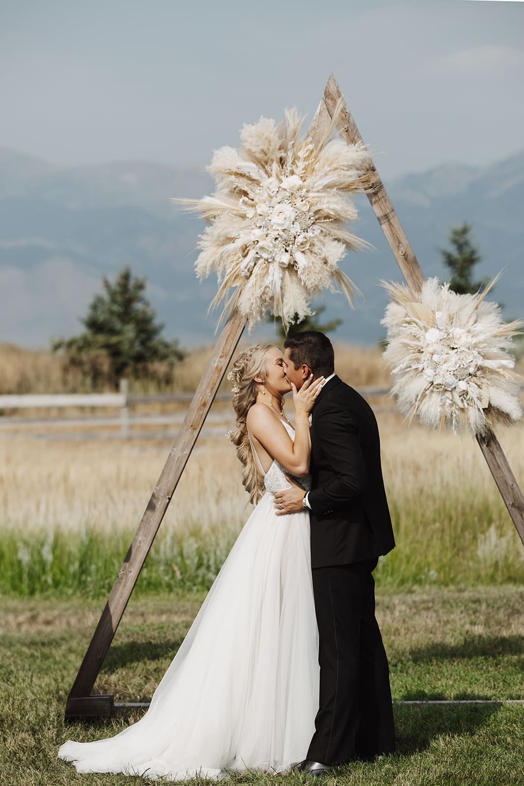 Bride and groom sharing their first kiss photographed by a bozeman wedding photographer.