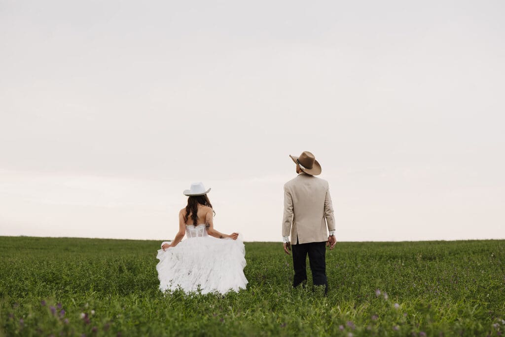 Bride and groom walking through a field photographed by montana wedding photographer frazier & co.