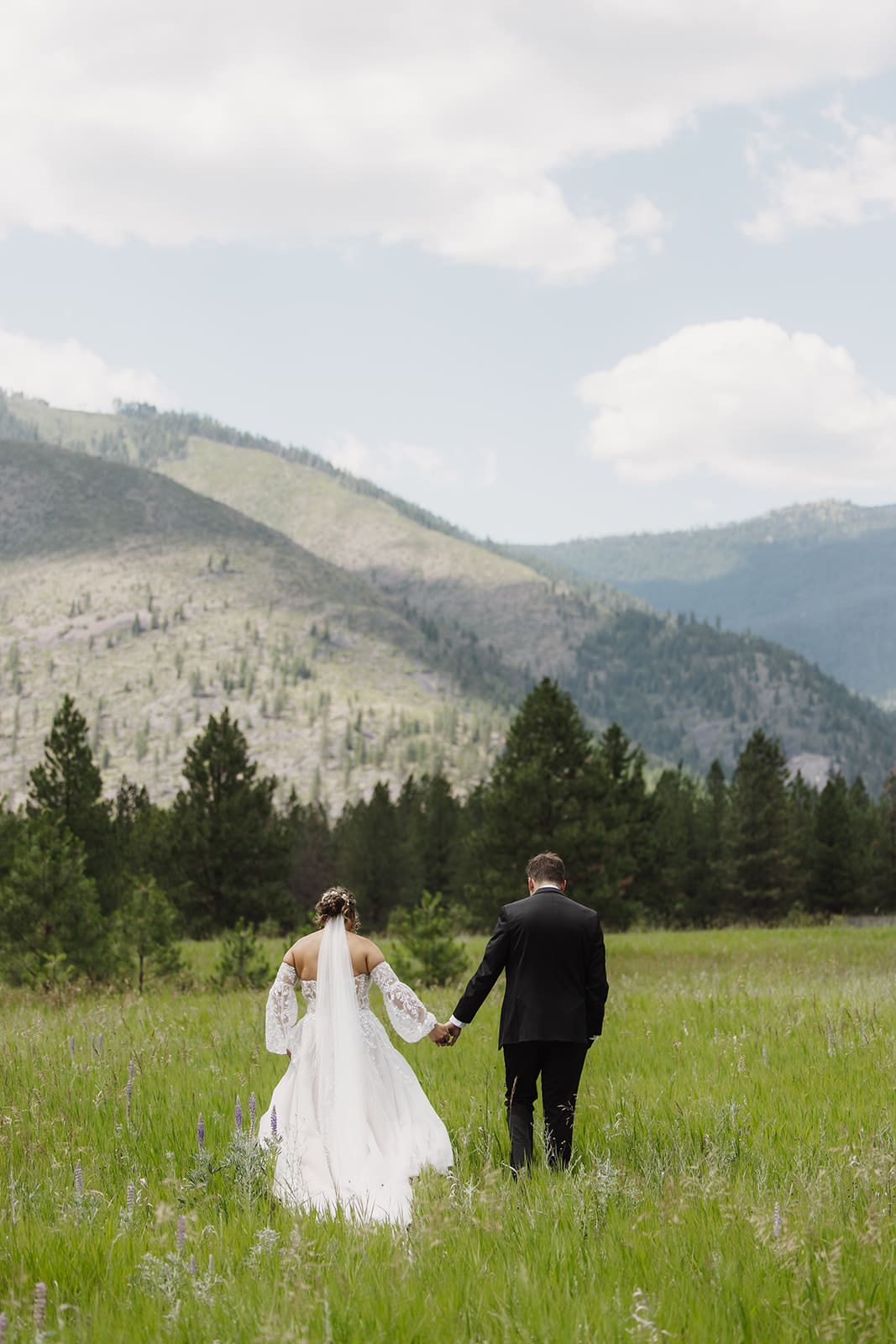 Bride posing in her wedding gown at The White Raven near Missoula, Montana, with natural light and elegant mountain scenery.