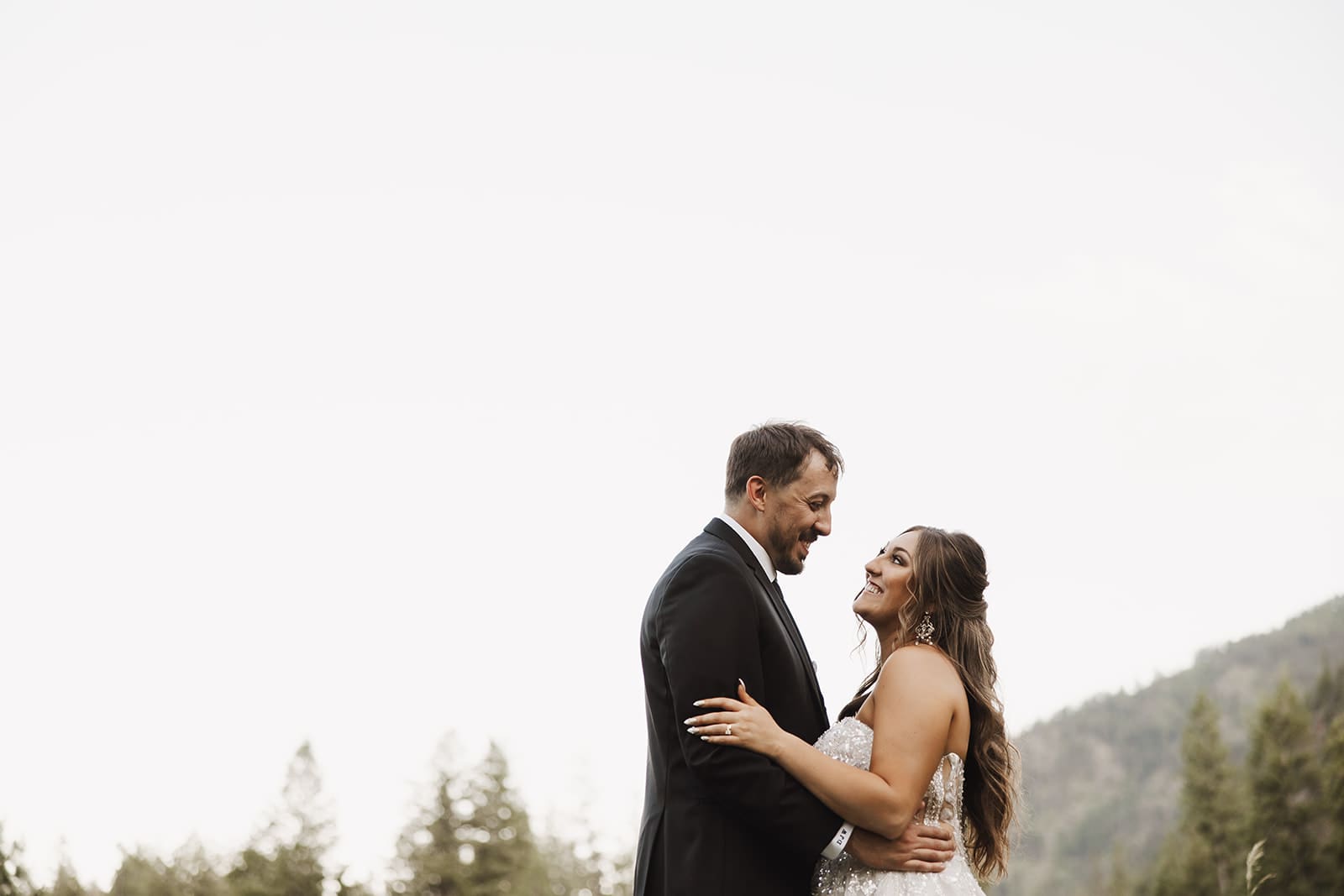 Bride and groom during golden hour portraits at The White Raven near Missoula, Montana, bathed in warm sunset light and surrounded by mountain views.