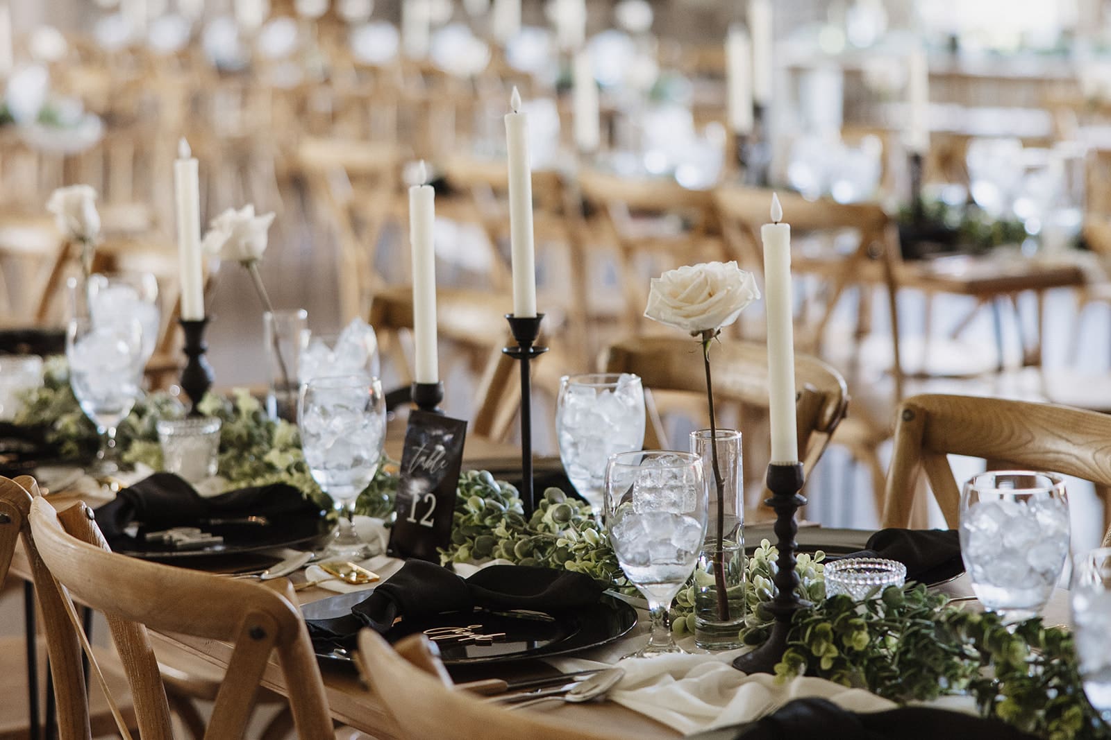 Elegant wedding reception setup at The White Raven venue near Missoula, Montana, featuring rustic wooden chairs, modern decor, and romantic floral details captured by Missoula wedding photographer Frazier & Co.