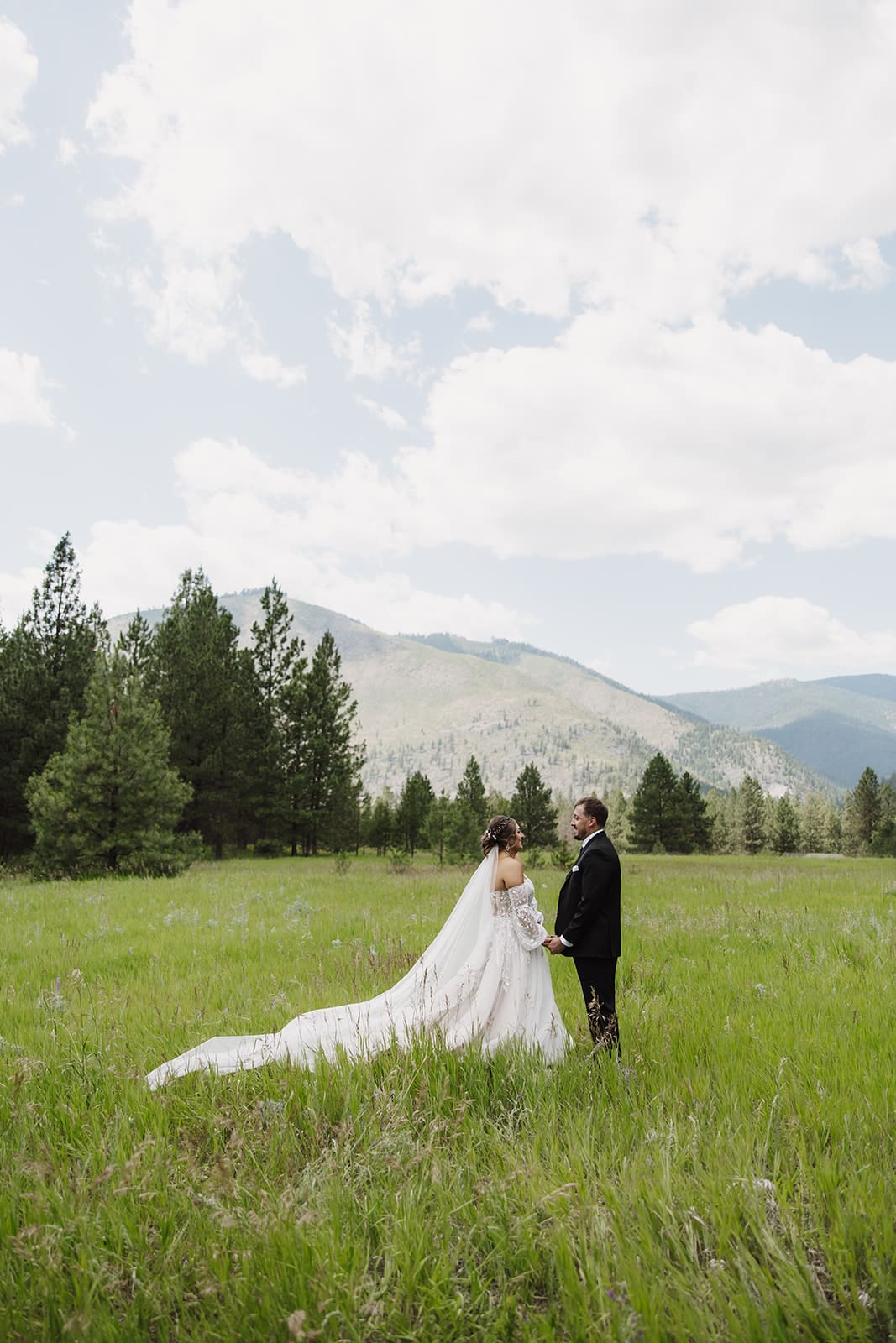 Emotional first look between bride and groom at The White Raven in Missoula, Montana, surrounded by pine trees and soft natural light.