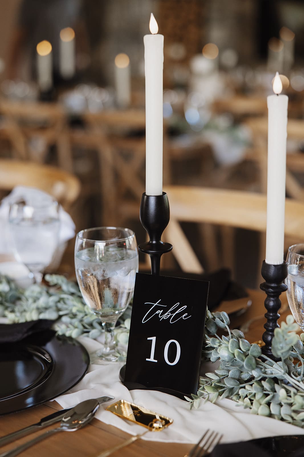 Elegant wedding reception setup at The White Raven venue near Missoula, Montana, featuring rustic wooden chairs, modern decor, and romantic floral details captured by Missoula wedding photographer Frazier & Co.