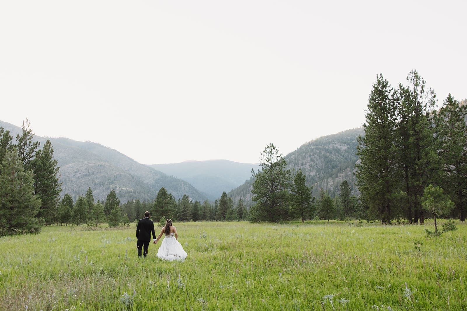 Bride and groom during golden hour portraits at The White Raven near Missoula, Montana, bathed in warm sunset light and surrounded by mountain views.