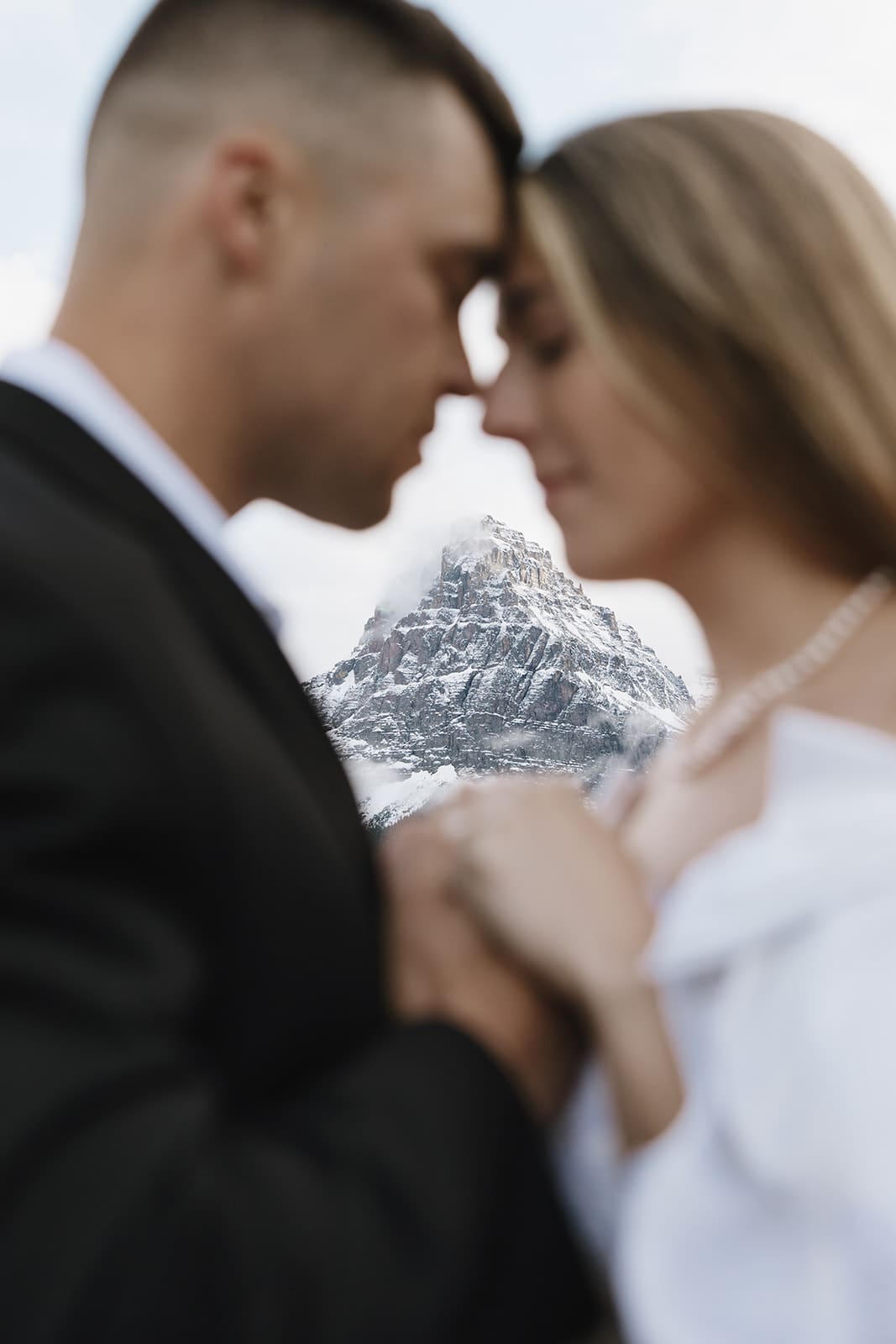 Glaciers peaking through a close up of bride and groom during montana elopement