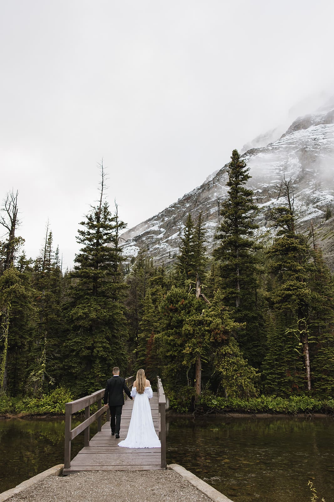 Bride and groom crossing bridge during their montana elopement taken by montana elopement photographer