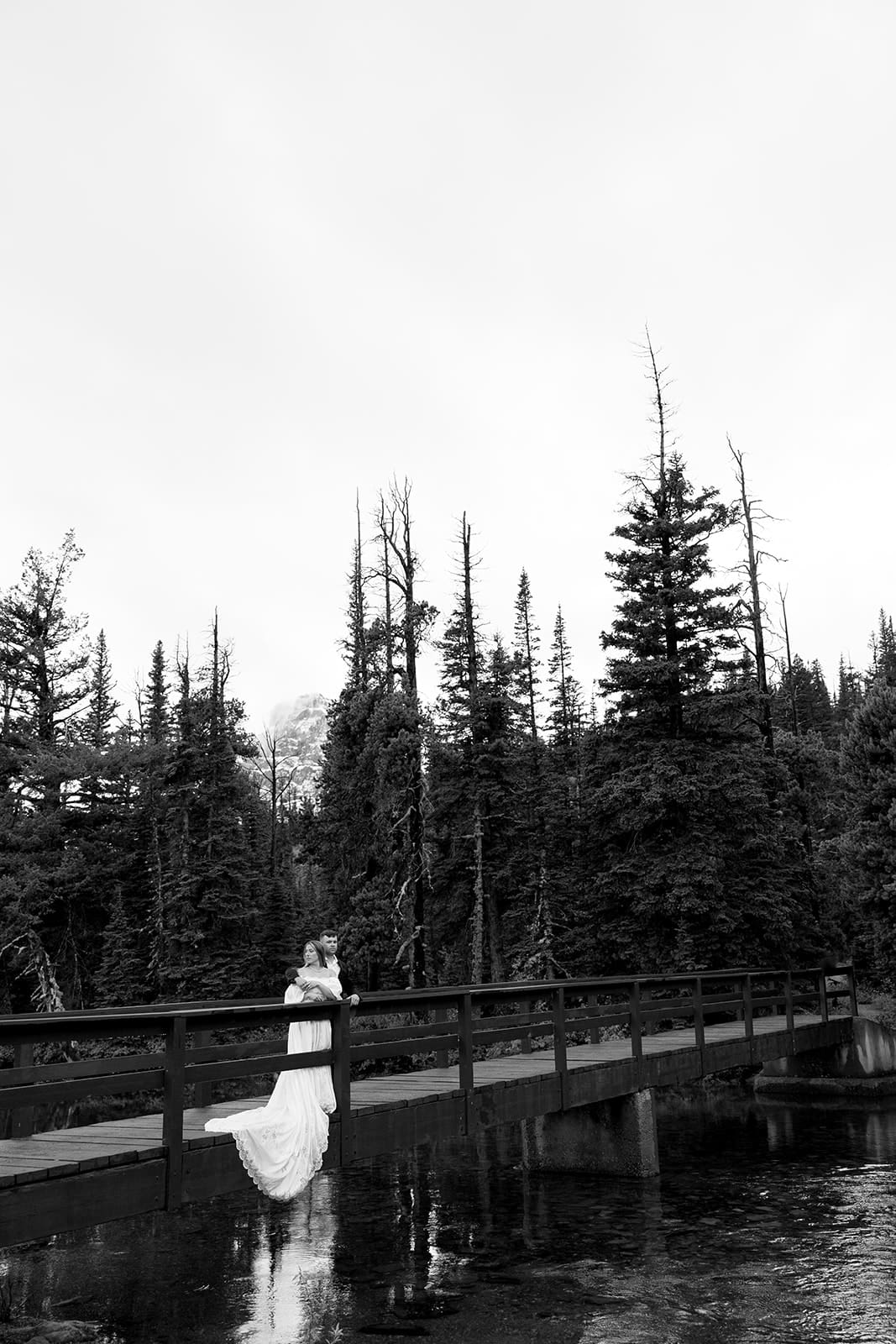 Bride and groom standing on a bridge in GNP during their elopement photos taken by montana elopement photographer