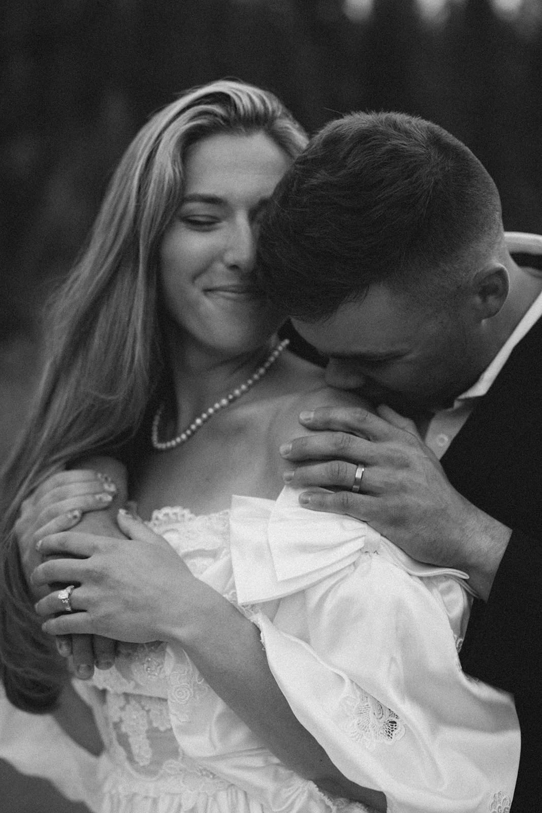 Black and white photo of montana elopement and groom is kissing brides shoulder