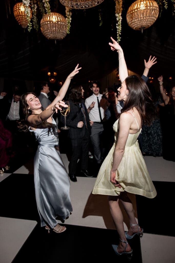 Guests dancing under chandeliers on the checkered dance floor during the Biltmore wedding reception.
