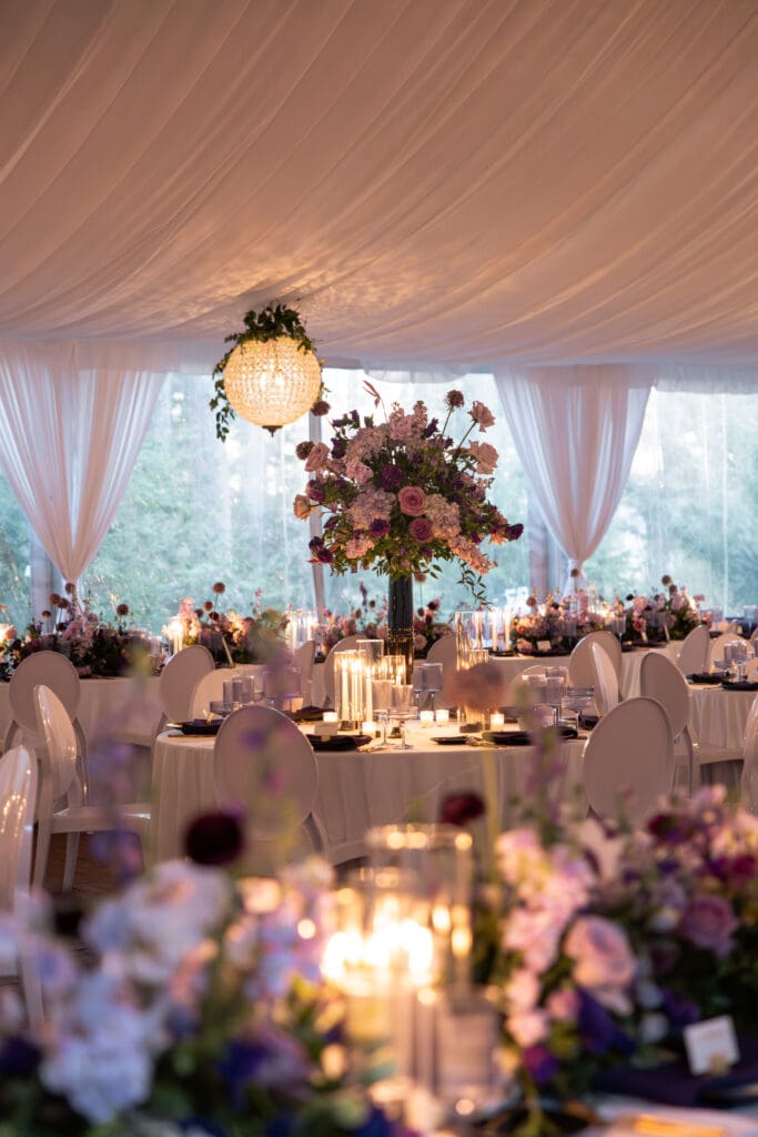 Luxury wedding reception tent at the Biltmore Estate with tall floral centerpieces and candlelit tables, featured in Biltmore wedding photos.