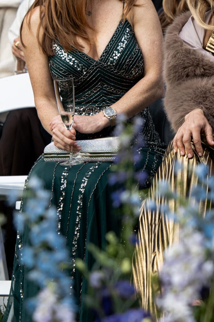 Guest in an emerald couture gown holding a champagne glass during a Biltmore Estate wedding, part of candid luxury Biltmore wedding photos.