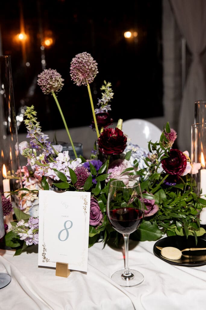 Luxury floral centerpiece featuring lavender, mauve, and deep burgundy blooms at a Biltmore wedding reception.