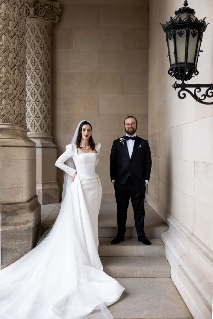 Bride and groom standing together in a stone archway at the Biltmore Estate, photographed by a Biltmore wedding photographer.”