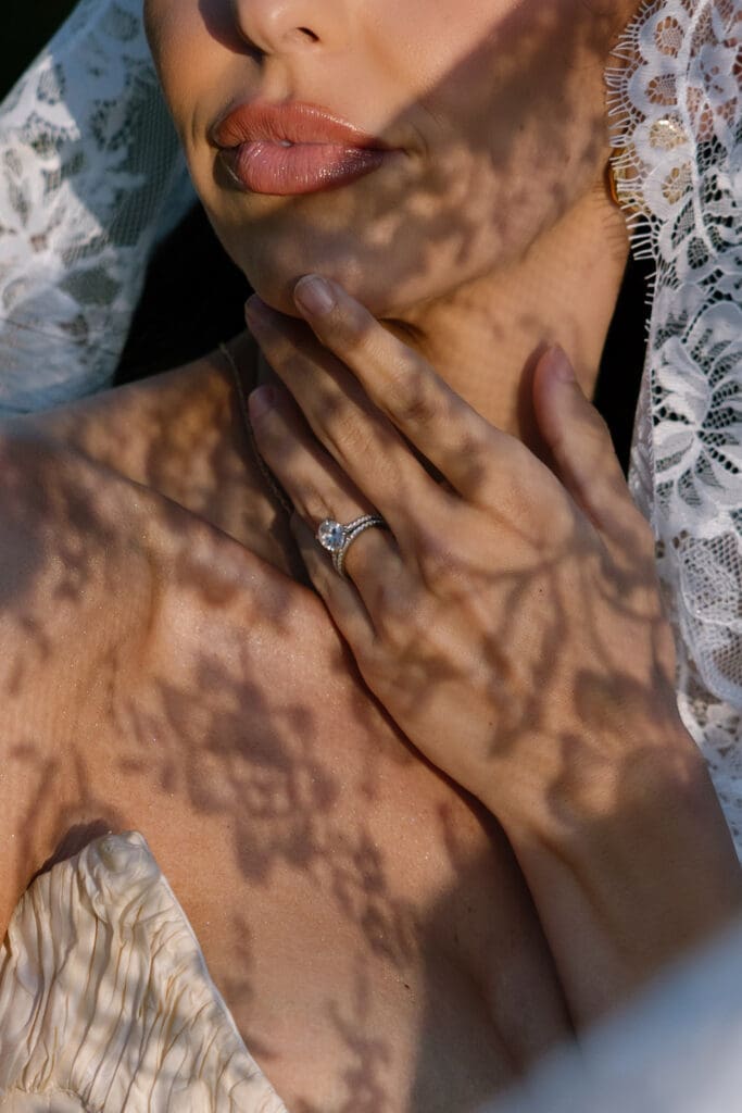 Close-up of bride’s face beneath lace veil with shadow detail.