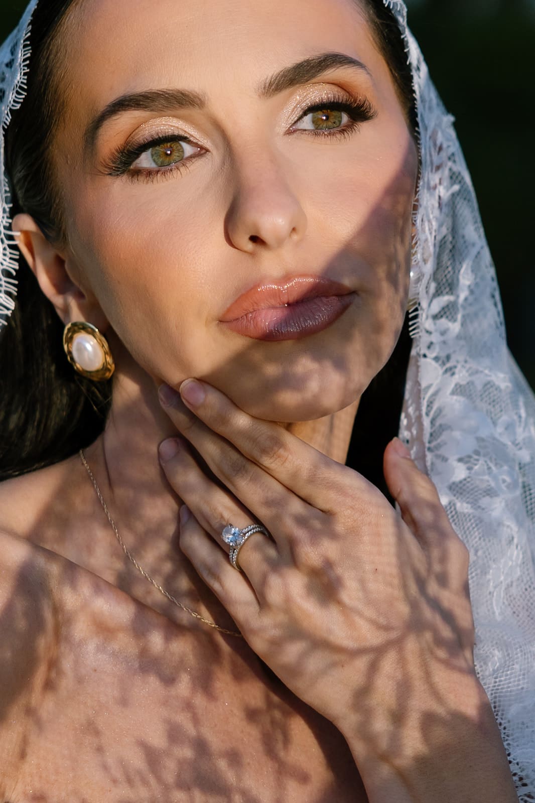 Editorial Colorado wedding photographer captures close-up bridal portrait with lace veil and dramatic shadow at Oceana’s Gardens in Boulder