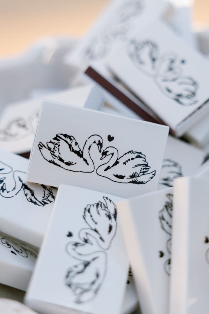 Stacked wedding favor boxes with monochrome illustration detail.