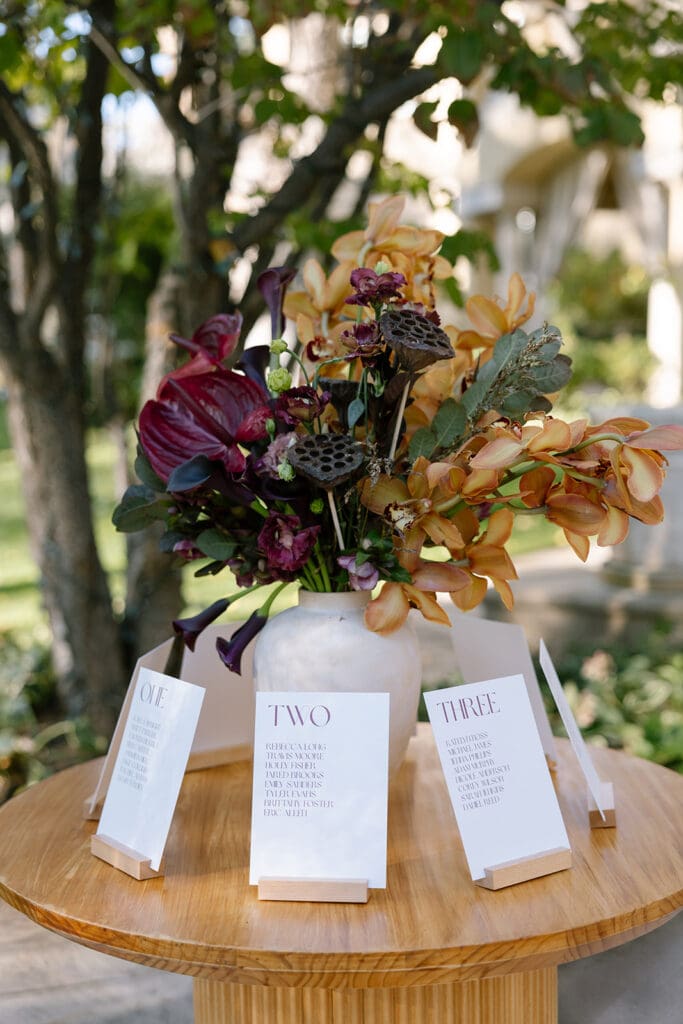 Wedding stationery displayed beside floral arrangement at Oceana’s Gardens.
