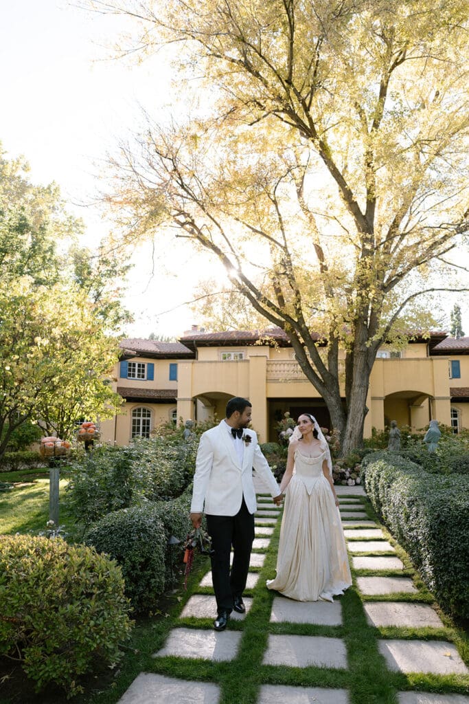 Bride and groom walking through the garden path at Oceana’s Gardens wedding venue.