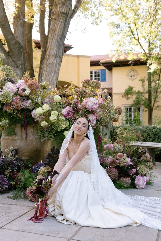 Bride seated among florals at Oceana’s Gardens captured by editorial wedding photographer in Boulder, Colorado.