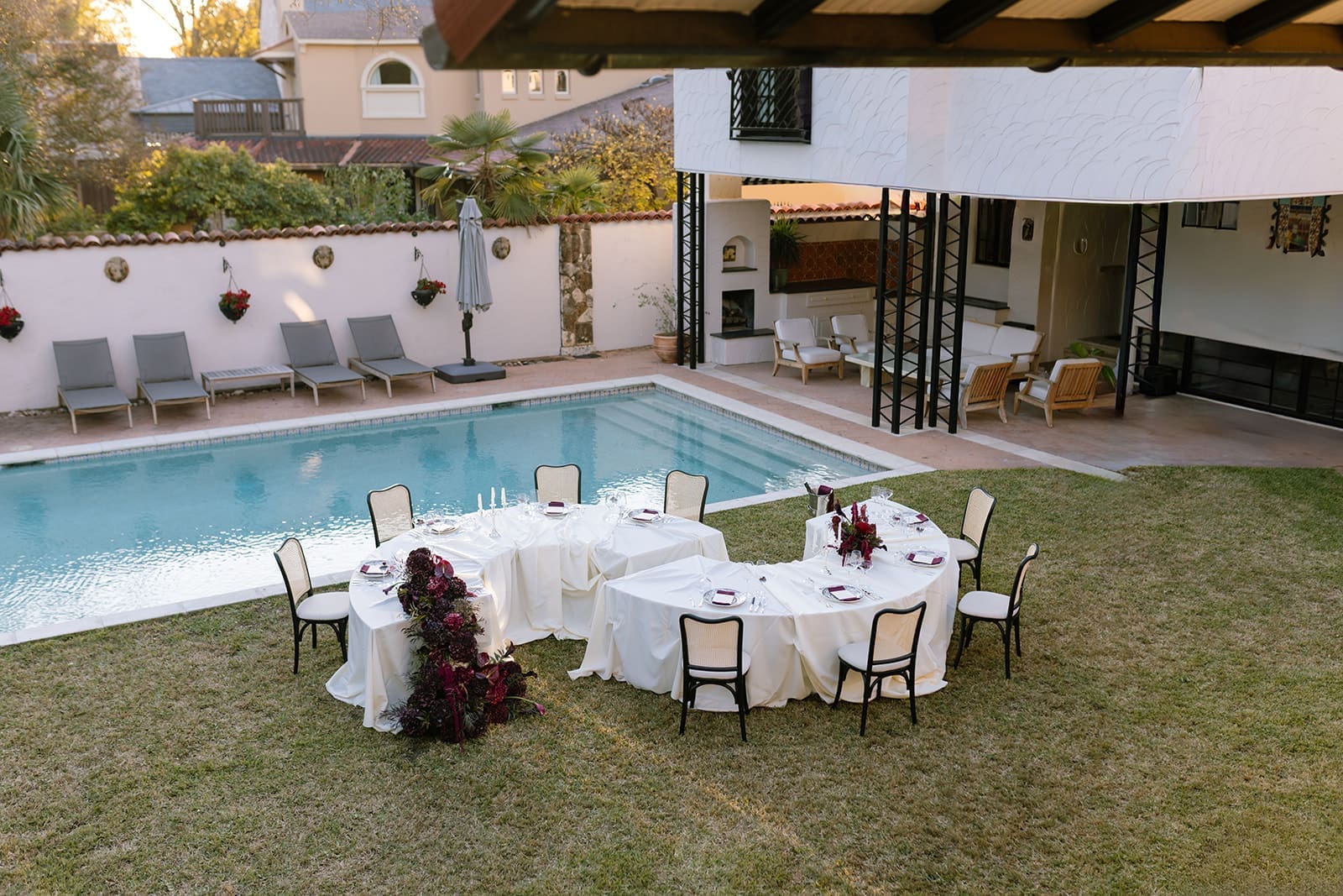 An elevated outdoor reception scene captured by Santa Barbara Editorial Destination Wedding Photographer Frazier & Co., featuring sculptural florals, refined tablescapes, and timeless architecture. This poolside estate setup showcases why California wedding venues outdoor are ideal for couples drawn to editorial, fashion-forward celebrations with a European-inspired atmosphere.