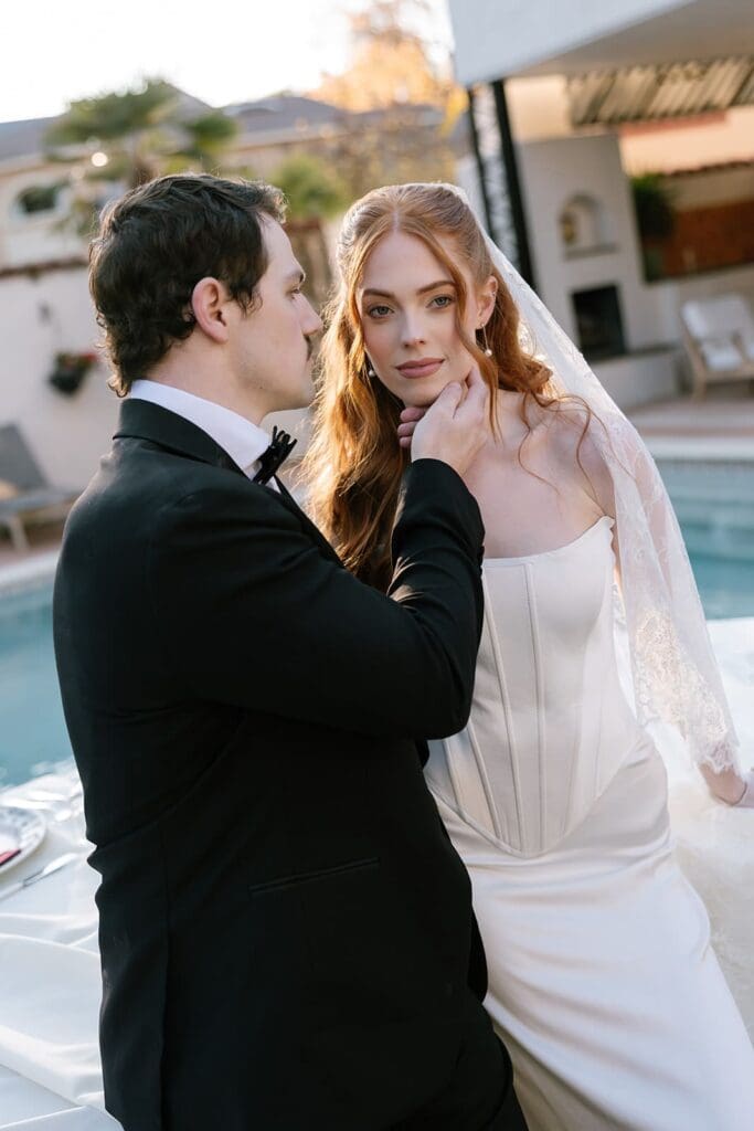 Editorial wedding couple posing poolside at Santa Barbara outdoor estate wedding venue.