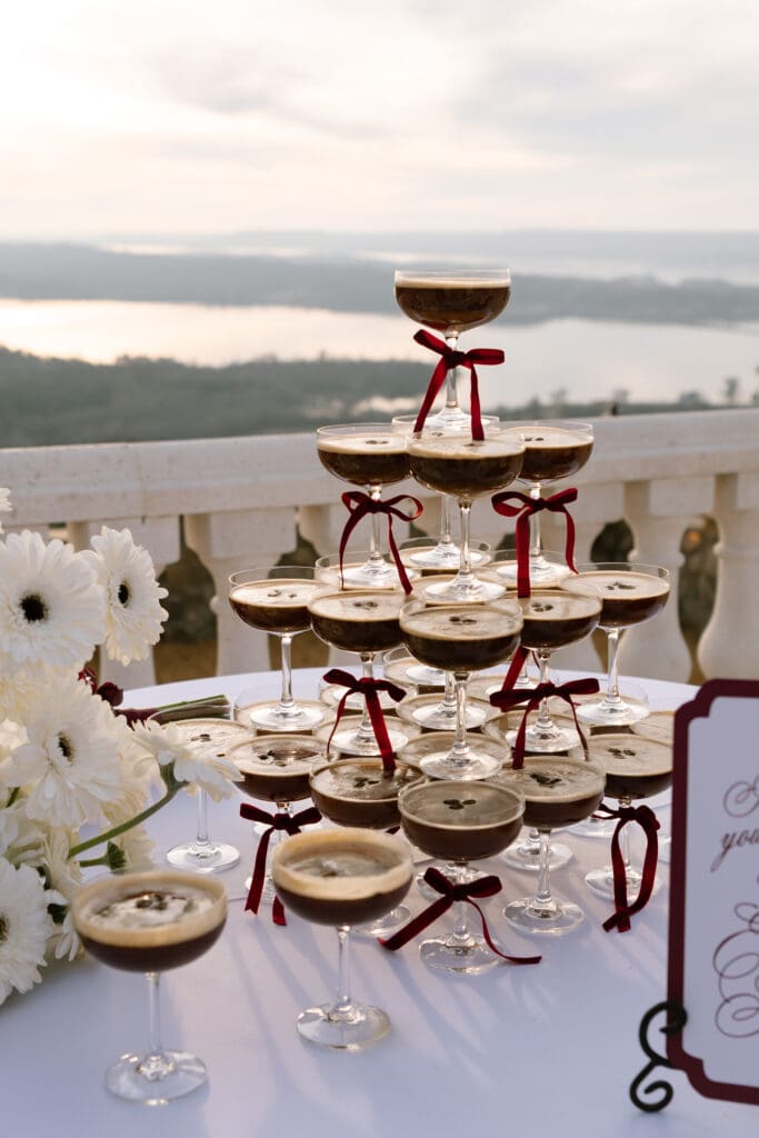 Editorial champagne-style espresso martini tower overlooking the river valley at Stone Haven wedding venue in Alabama photographed during golden hour.