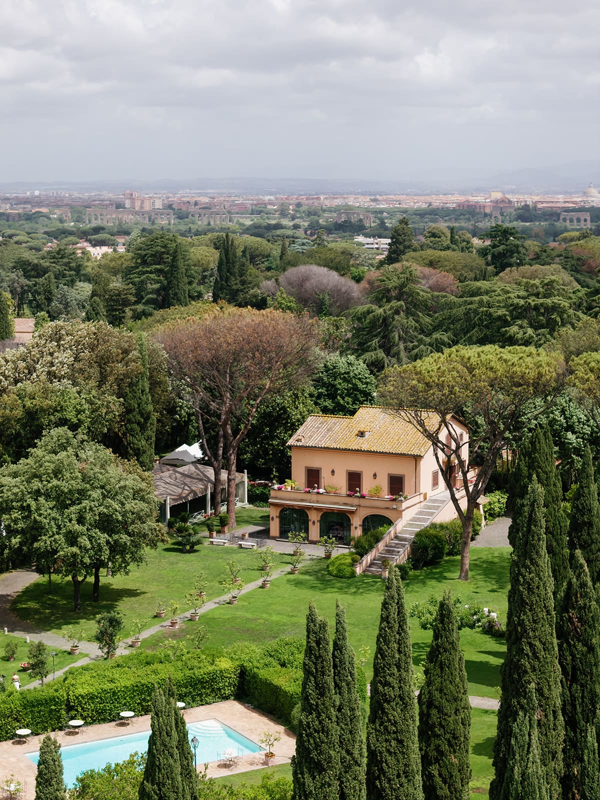 Relais Appia Antica luxury estate in Rome with cypress trees, manicured gardens, villa architecture, and swimming pool aerial view