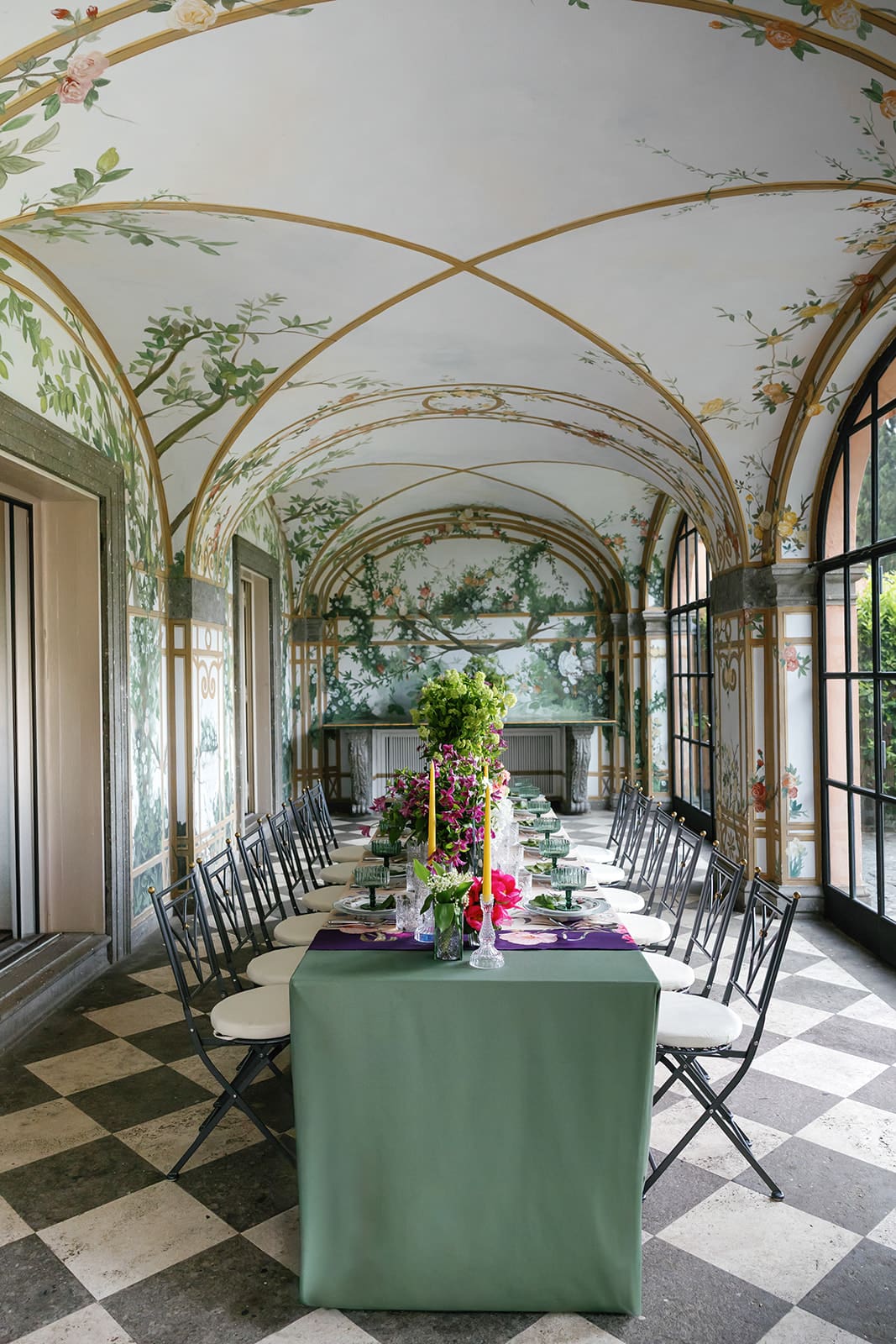 Luxury Rome wedding reception venue with botanical wallpaper backdrop, arched ceilings, and elegant table settings with green linens at Relais Appia Antica, photographed by editorial wedding photographer Frazier & Co.
