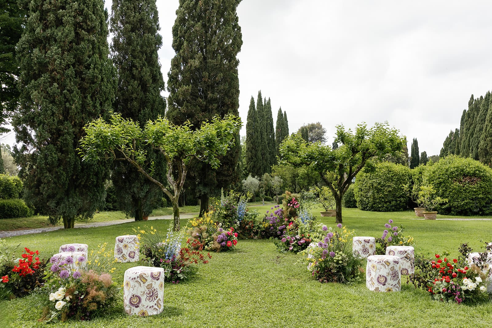 Relais Appia Antica estate grounds in Rome with cypress trees, manicured gardens, and floral arrangements, luxury destination wedding venue.