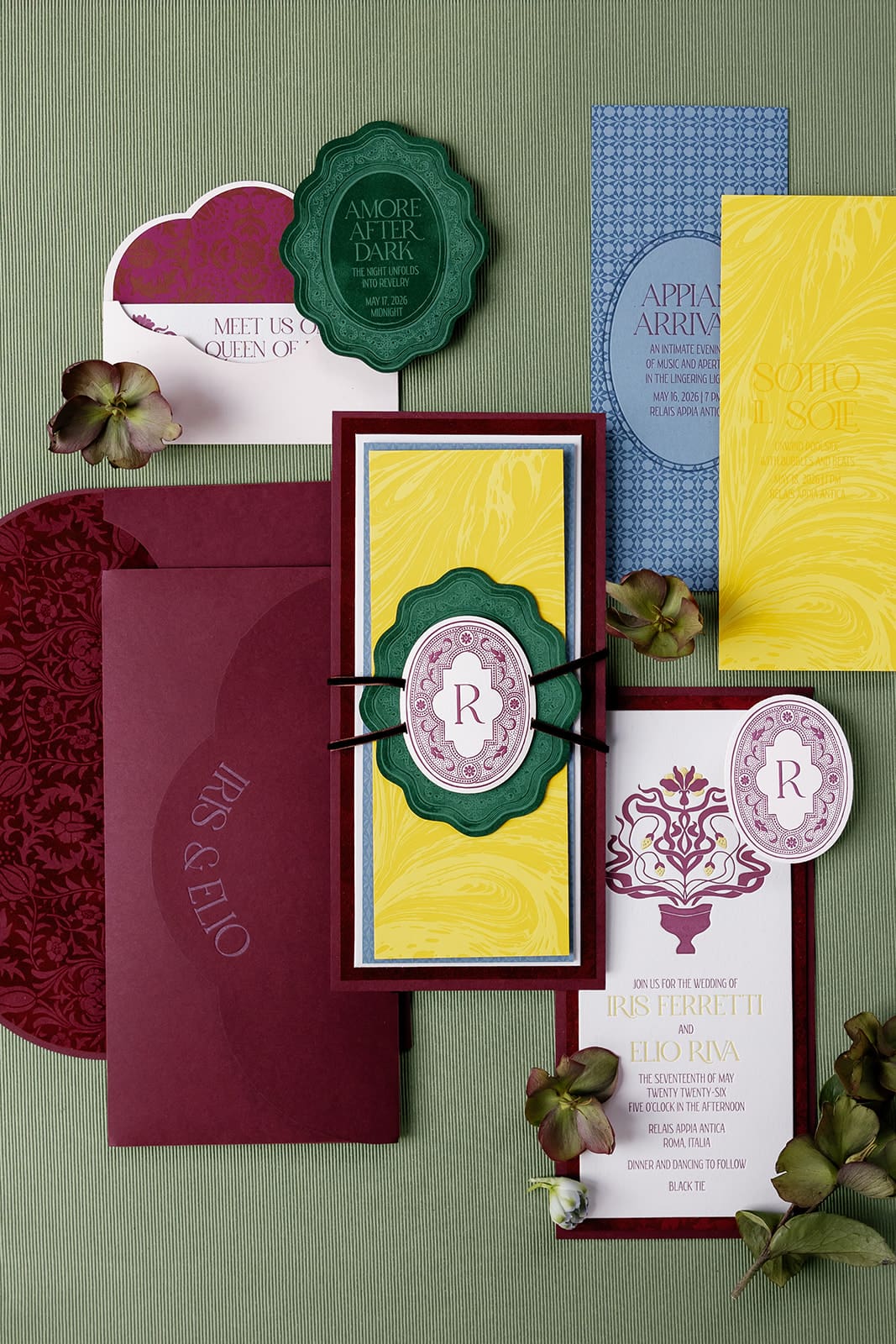 Luxury wedding stationery flat lay with burgundy, cream, and gold botanical design elements and wax seals for Rome destination wedding
