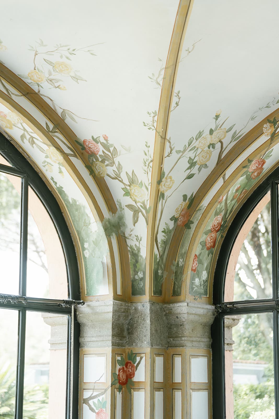 Classical conservatory interior with arched ceilings, botanical wallpaper, and warm architectural lighting at luxury Rome destination wedding venue