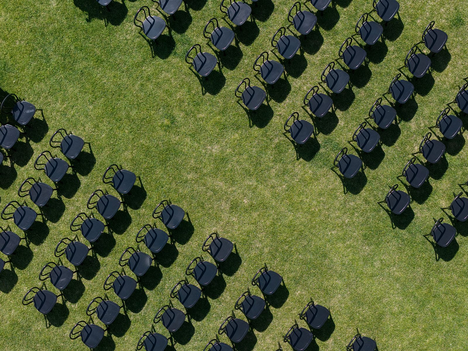Aerial view of empty ceremony chairs arranged in diagonal rows on the lawn at Montage Big Sky