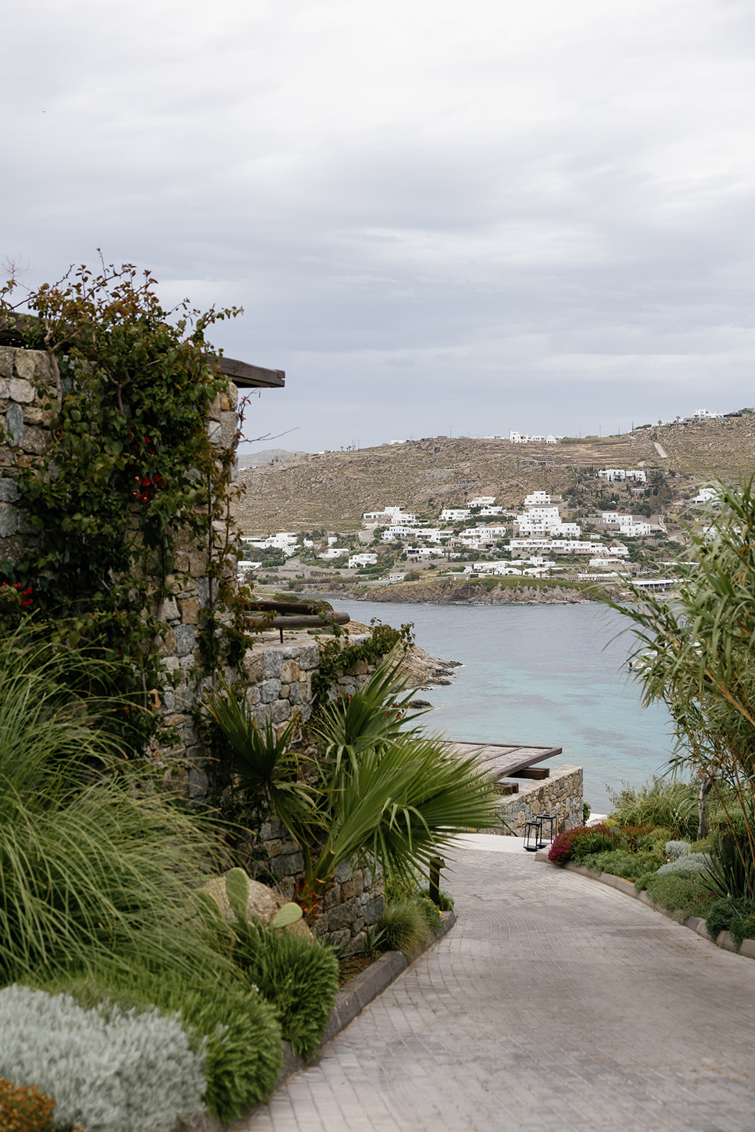 Elevated coastal view of a secluded turquoise bay surrounded by the rocky landscape of Mykonos, Greece.