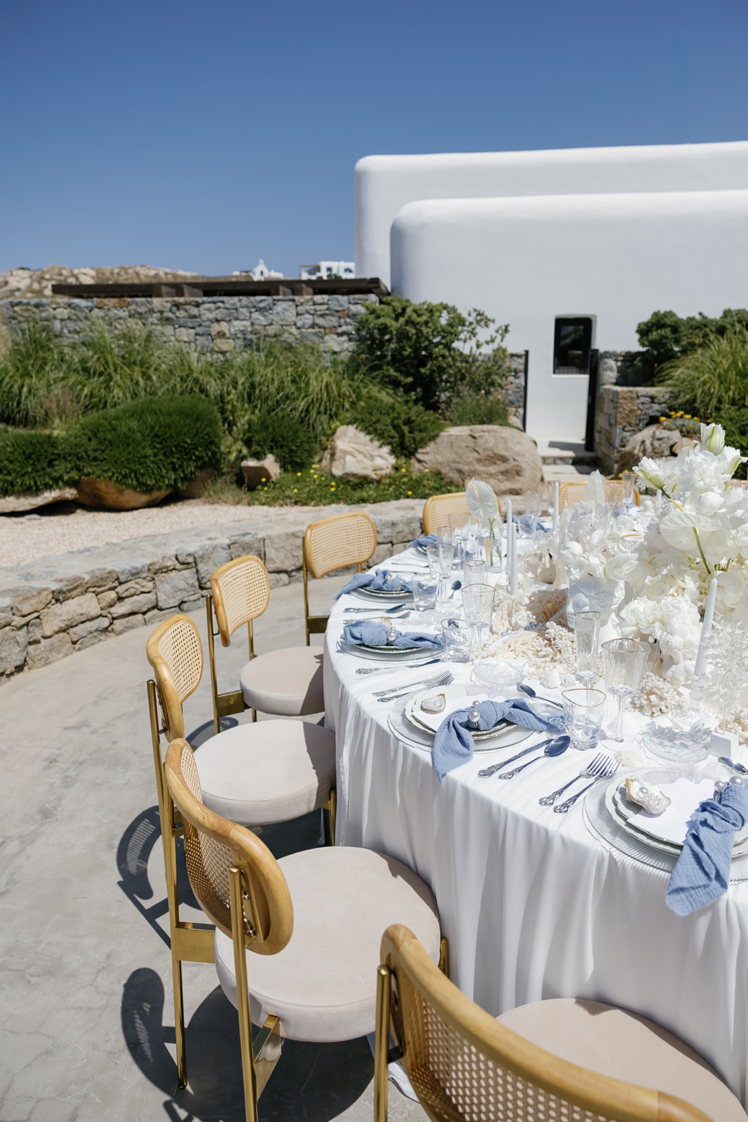 Luxury wedding reception table styling featuring white florals, gold accents, and delicate decorative details in Mykonos.