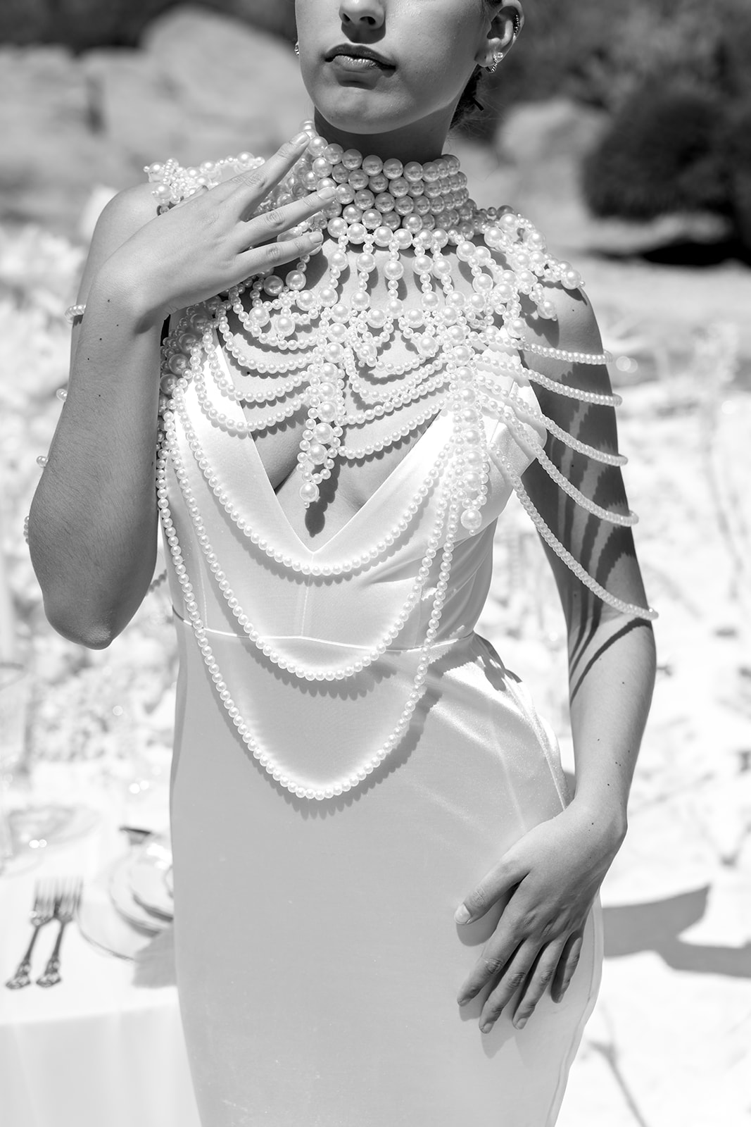 Black and white editorial bridal fashion photograph highlighting sculptural gown details and intricate embellishments.