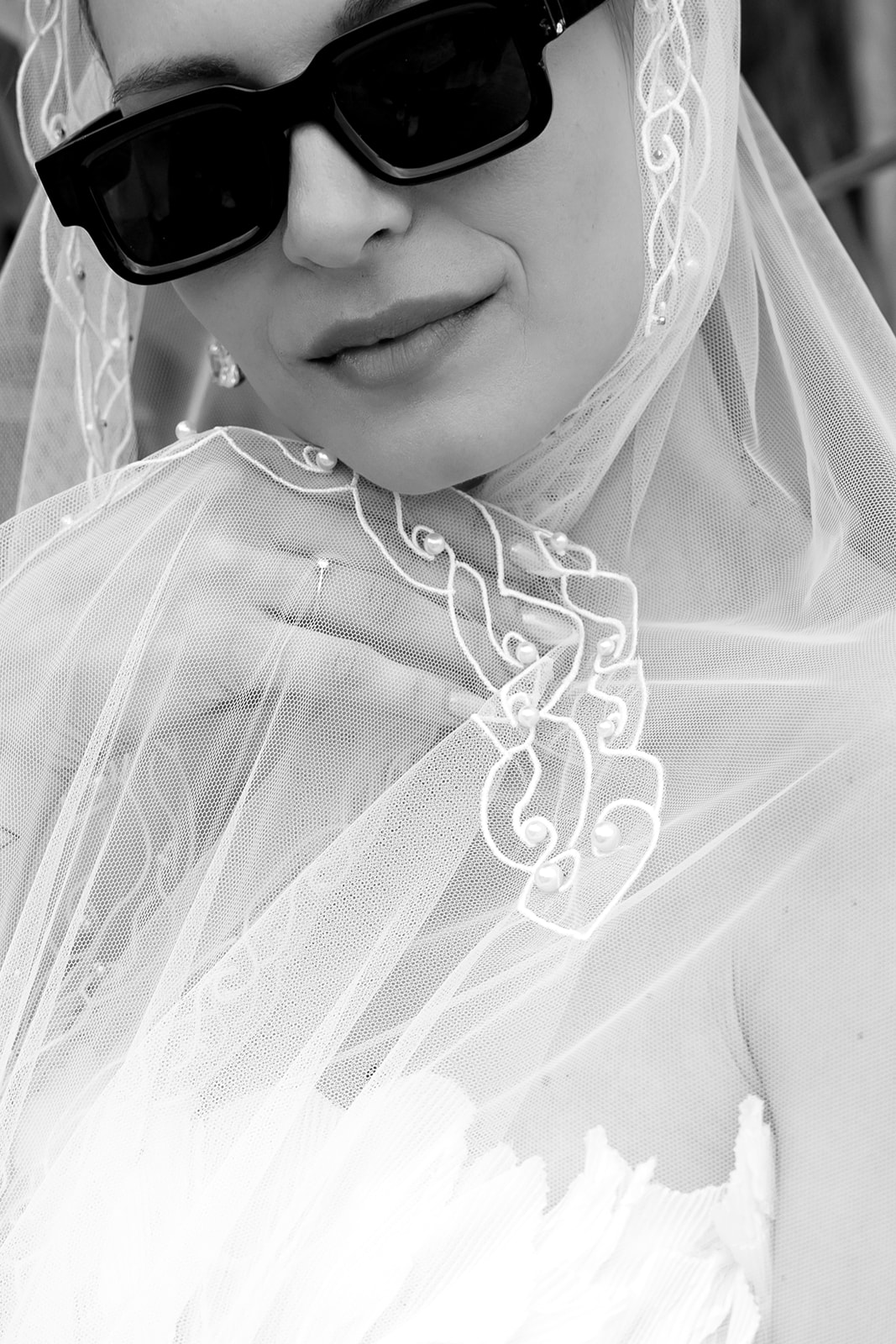 Close up black and white bridal portrait highlighting intricate lace veil details and elegant wedding styling in Mykonos, Greece.